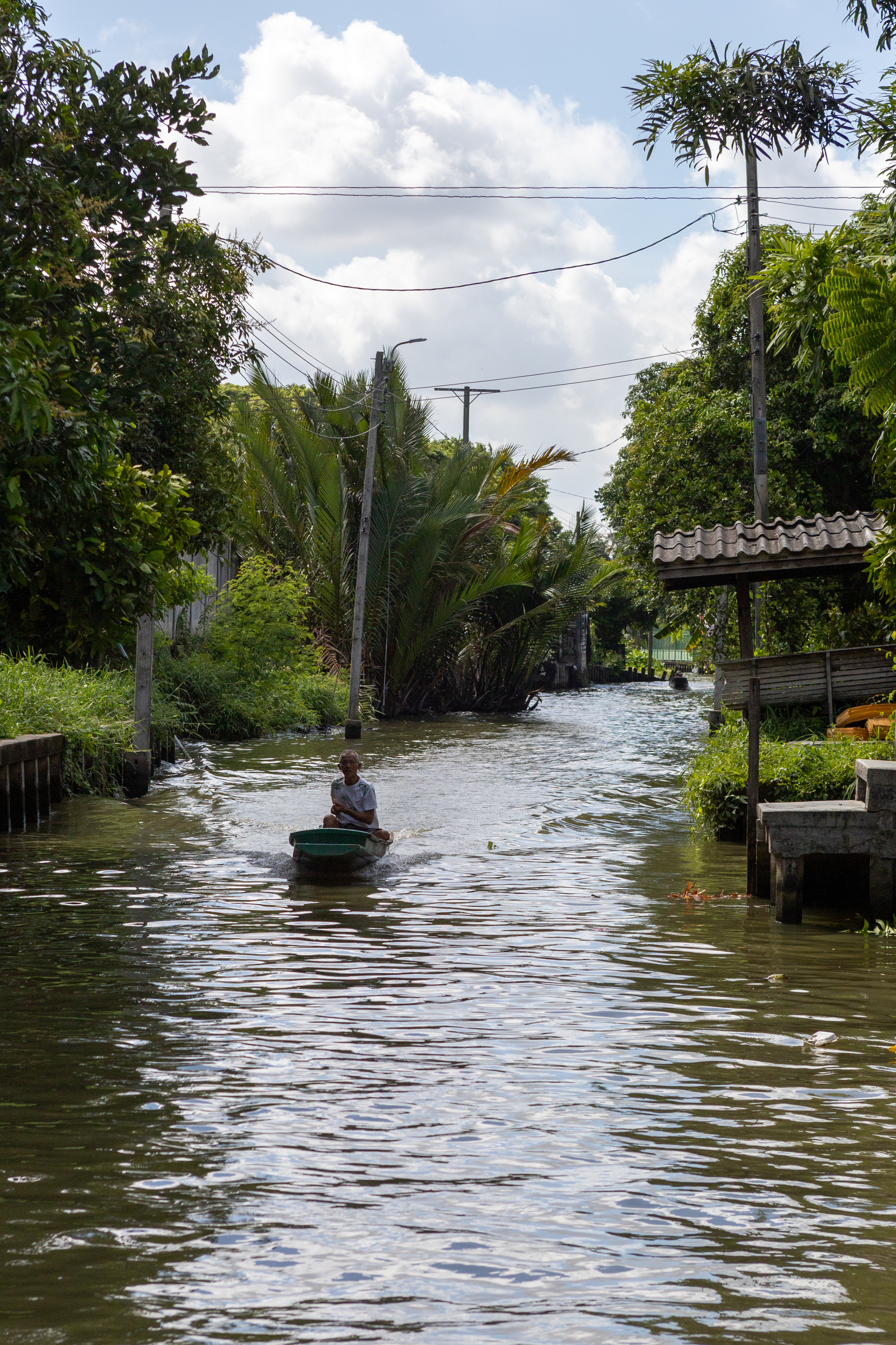 A local boat carrying a passenger along the canal on the way to the coconut farm.