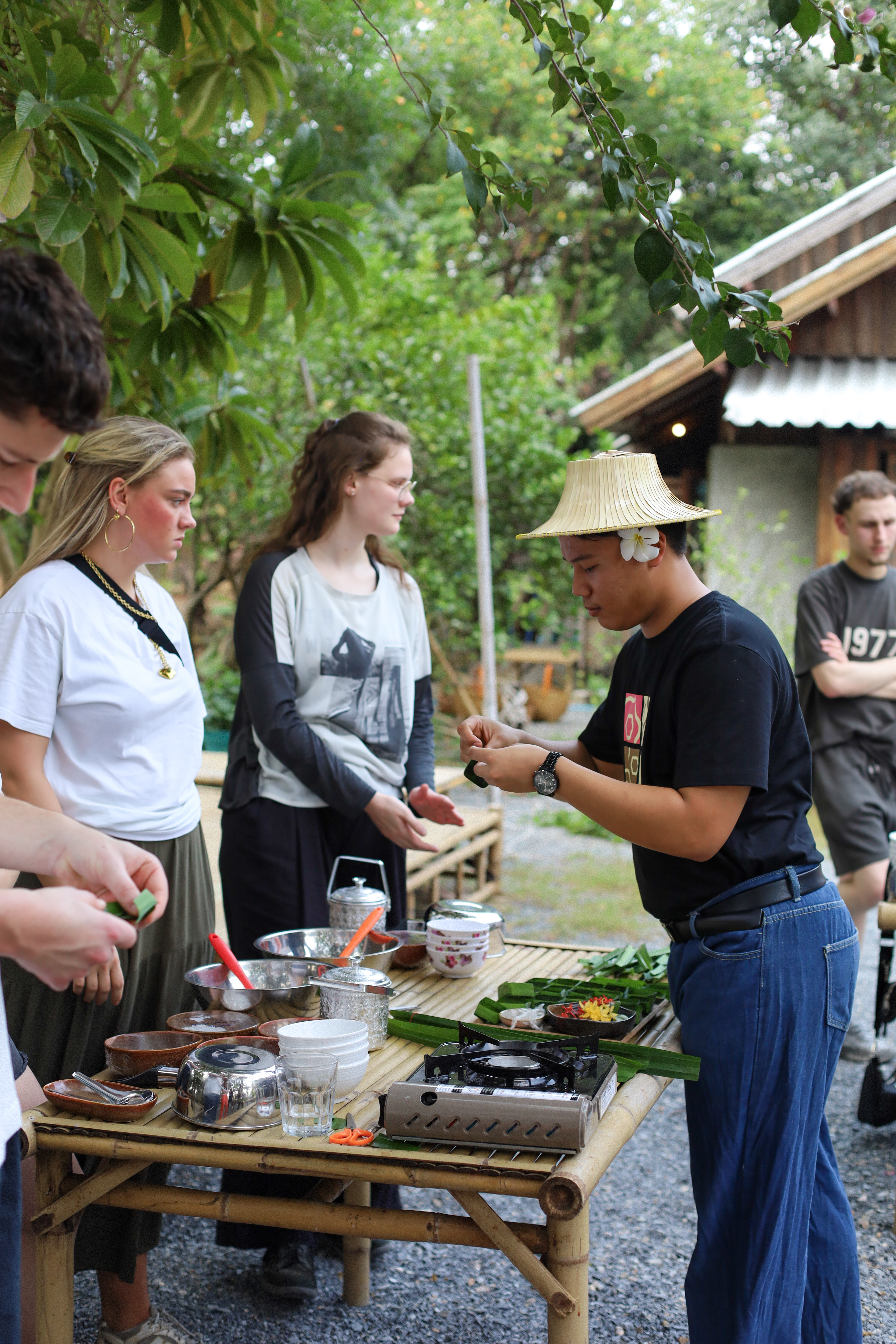 A guide preparing ingredients near the garden's plant information boards during the workshop.