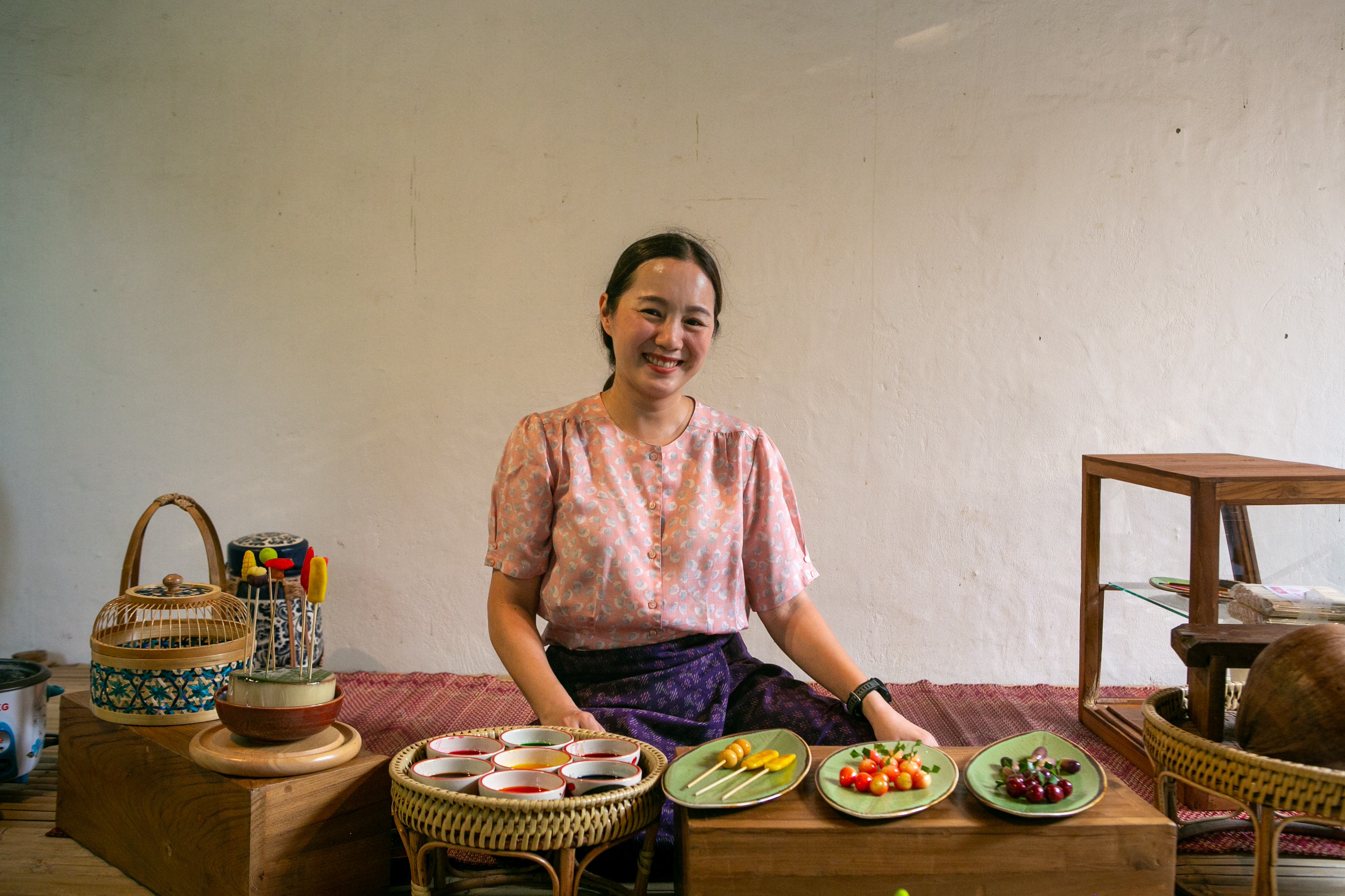 Bowls of pastel dumplings finished with a pandan leaf garnish, placed by hand.