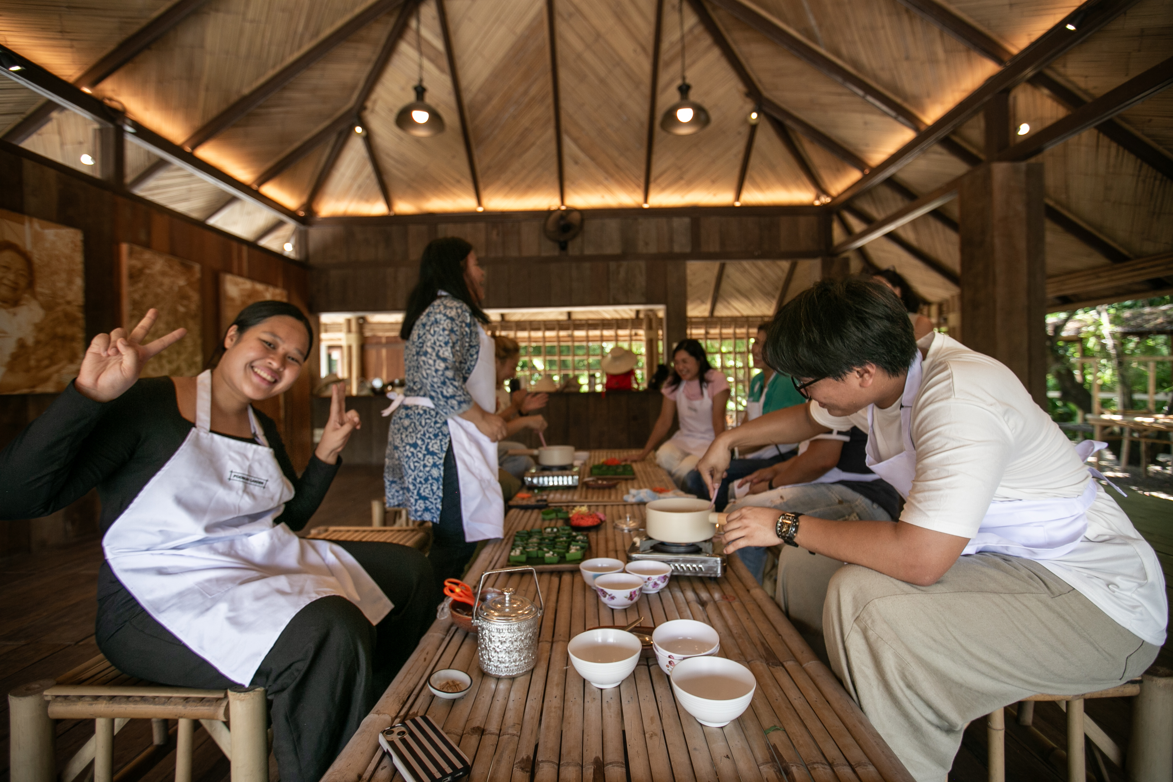 Guests gathered around a low bamboo table during a Thai dessert-making session.