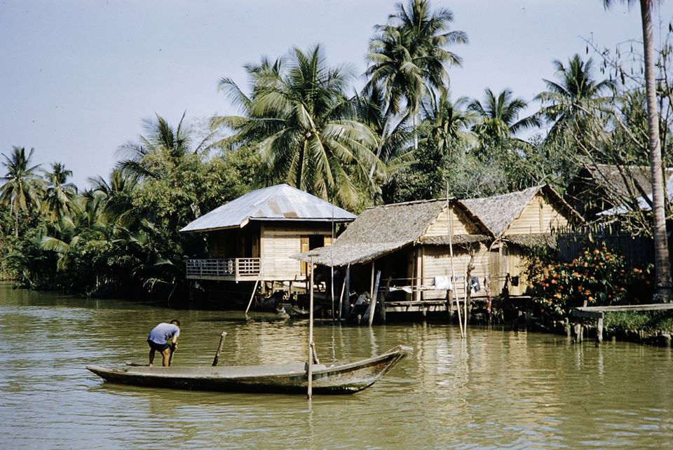 Archival photo of wooden boats loaded with pineapples and produce at a floating market stall.