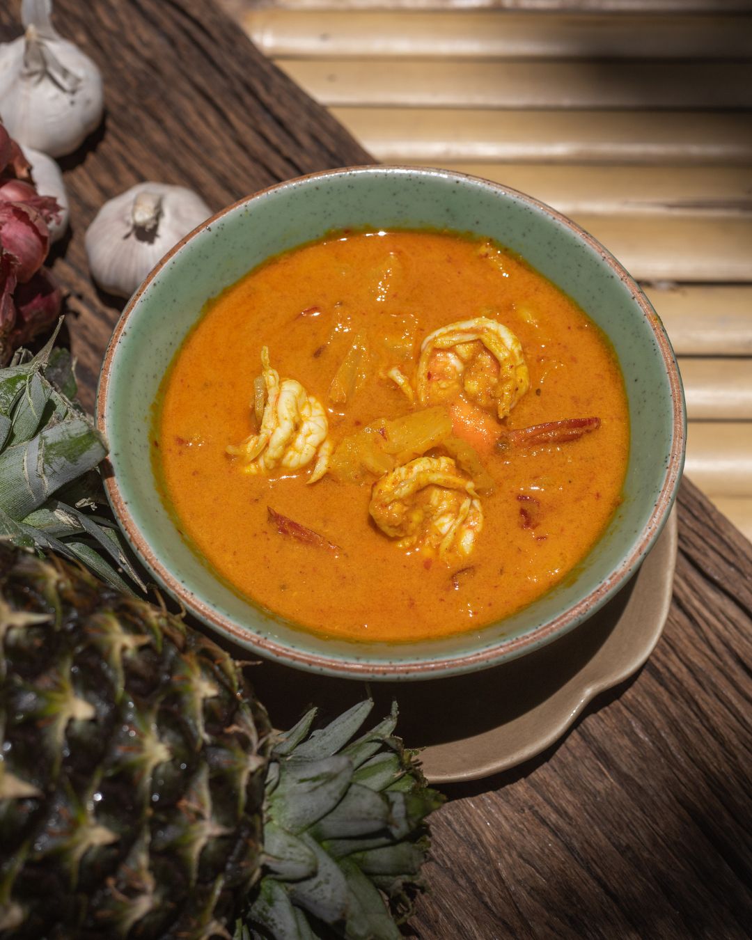 A bowl of prawn curry garnished with fresh herbs at Natura Caf&eacute;.