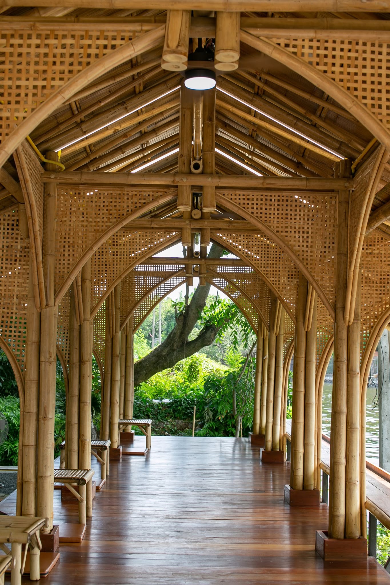 The bamboo pavilion dining room at Natura Caf&eacute;, with woven lattice walls and arched columns overlooking the canal.